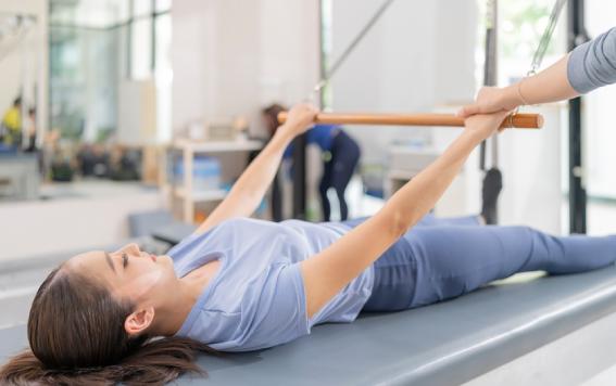 Man performing exercises on Studio Reformer Tower at Intelligent Movement